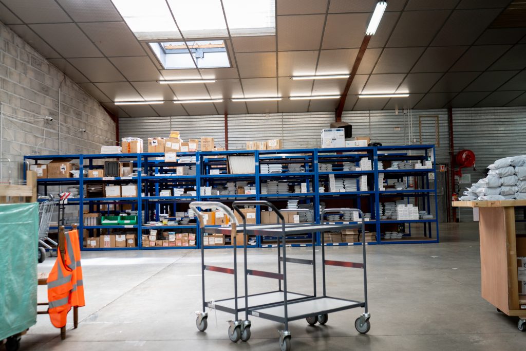 corner-of-spriiint-warehouse A corner of Spriiint warehouse with shelves and trolleys.